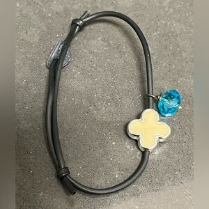 Adjustable knock off van cleefs style bracelet. Black rubber adjustable band.